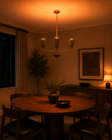 Milan Cone Arm Chandelier installed above a round dining table in a warm modern interior.