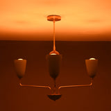 Milan Cone Arm Chandelier glowing warmly in low light with three upward-facing cone shades.