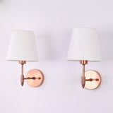 Pair of Milan copper antique wall sconces with white tapered fabric shades mounted on a wall, ideal for bedside lighting, hallways, bathrooms, and modern transitional interiors.
