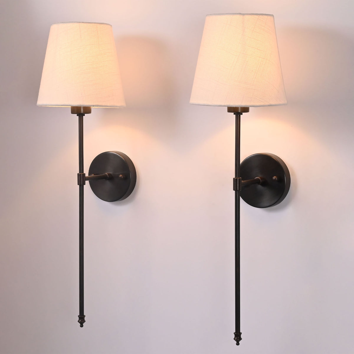 Pair of Milan ivory shade black rod wall sconces with tall slim frames and warm ambient glow.