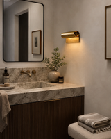Milan Modern Picture Light installed above a bathroom vanity, providing warm focused illumination with a modern solid brass finish in a contemporary interior.