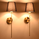 Pair of illuminated navy shade wall sconces creating warm ambient glow with refined classic styling.