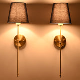 Milan navy shade wall sconces glowing warmly with tall rod frames and soft wall illumination.