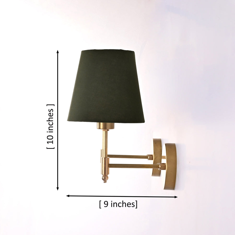 Milan brushed brass wall sconces with olive green fabric shades installed in a luxury hotel-style living room beside framed artwork and a console table.