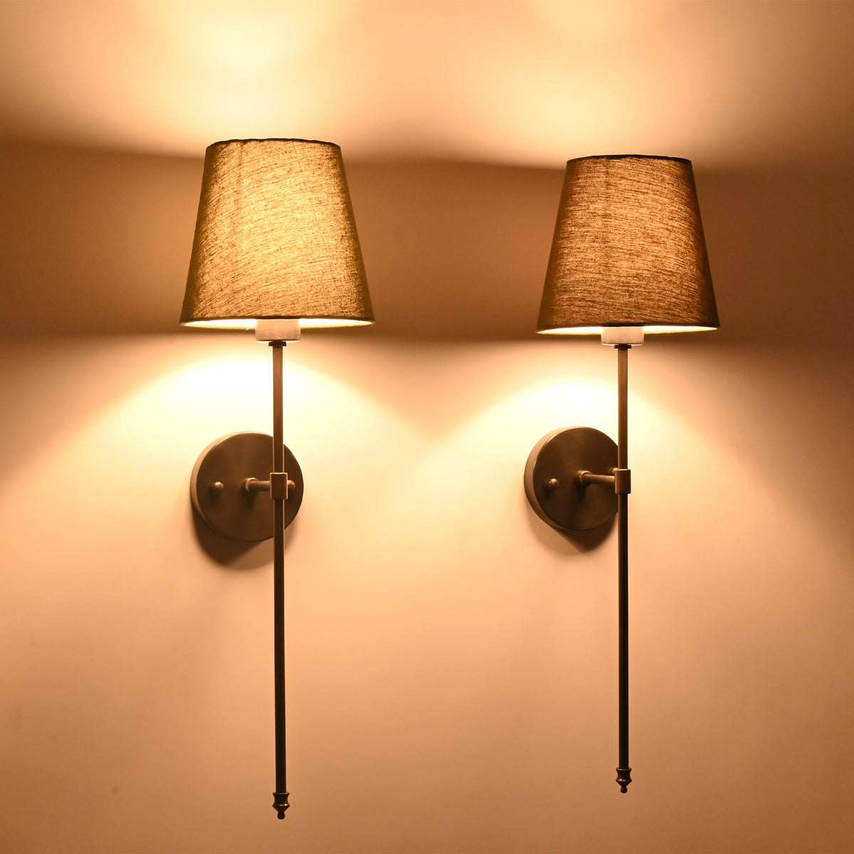 Illuminated olive shade black rod wall sconces creating moody warm light for classic interiors.