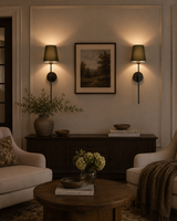 Milan olive shade black wall sconces installed beside framed artwork in a moody classic living room.