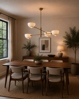 Milan 4-light opal bowl chandelier with warm brass frame displayed above a wooden dining table in a modern dining room.