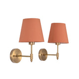 Pair of Milan Peach Shade Antique Brass Short Wall Sconces displayed with peach fabric shades and antique brass finish.