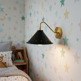 Front view of Milan 1 light wall sconce with perforated black cone shade and warm brass hardware.