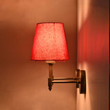 Close illuminated pair view of Milan red shade wall sconces with rich red fabric texture and warm wall lighting.