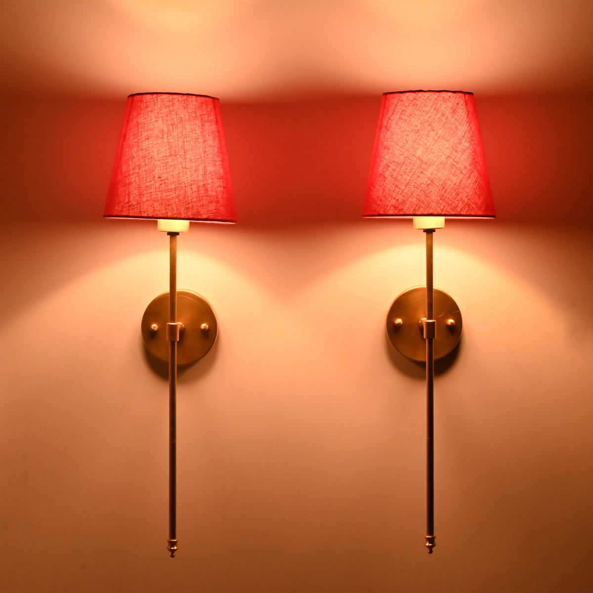 Pair of tall red shade rod wall lights with soft glow, ideal for bedroom or hallway interiors.