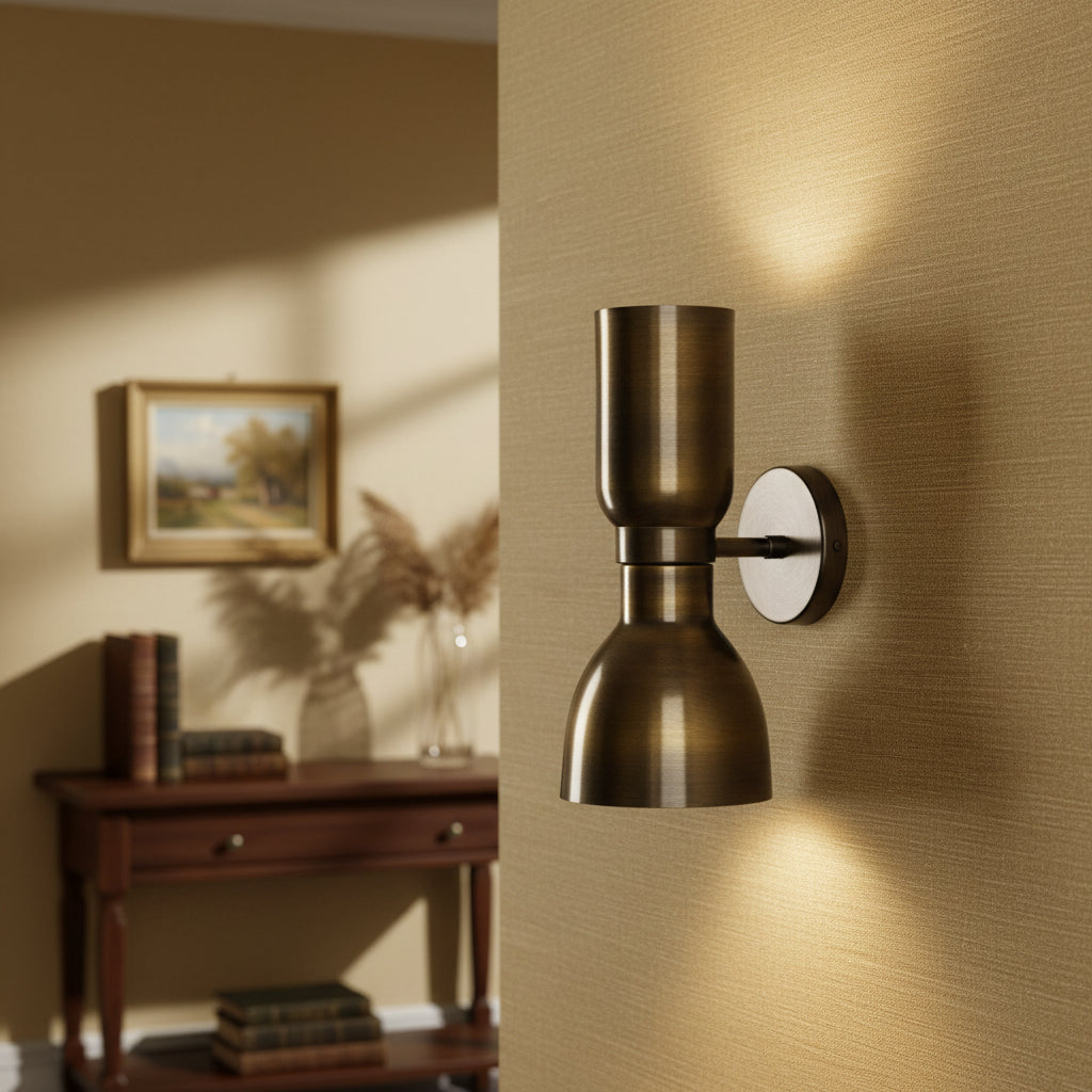 Close-up view of Milan hourglass 2-light wall sconce in antique brass finish with sculptural metal shade design.