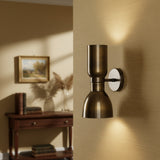 Close-up view of Milan hourglass 2-light wall sconce in antique brass finish with sculptural metal shade design.