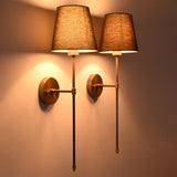 Angled view of Milan Shade Rod Wall Sconce pair highlighting round backplates, straight arms, and tall rod design.