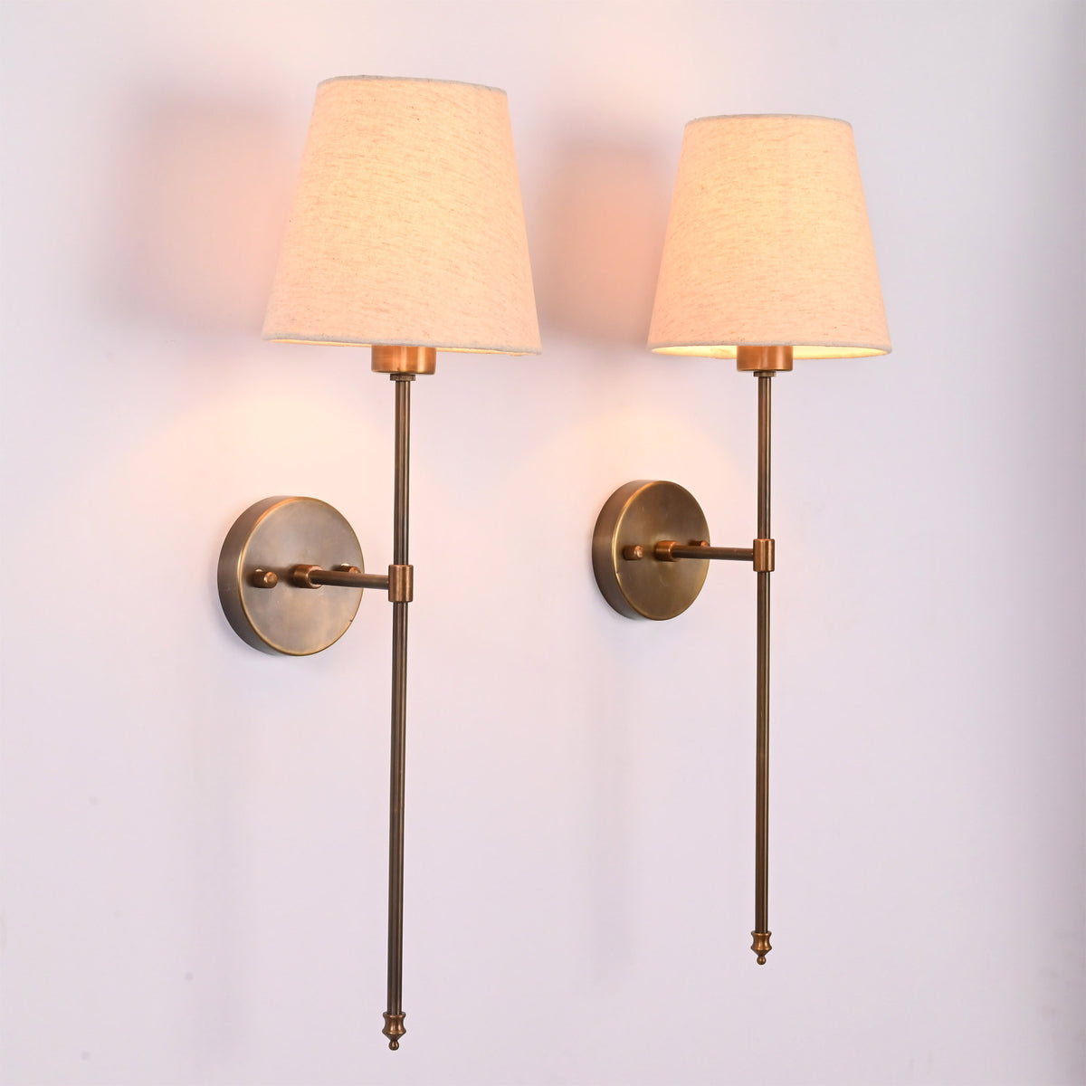 Angled view of Milan Shade Rod Wall Sconce pair with round backplates, fabric shades, and slim rods.
