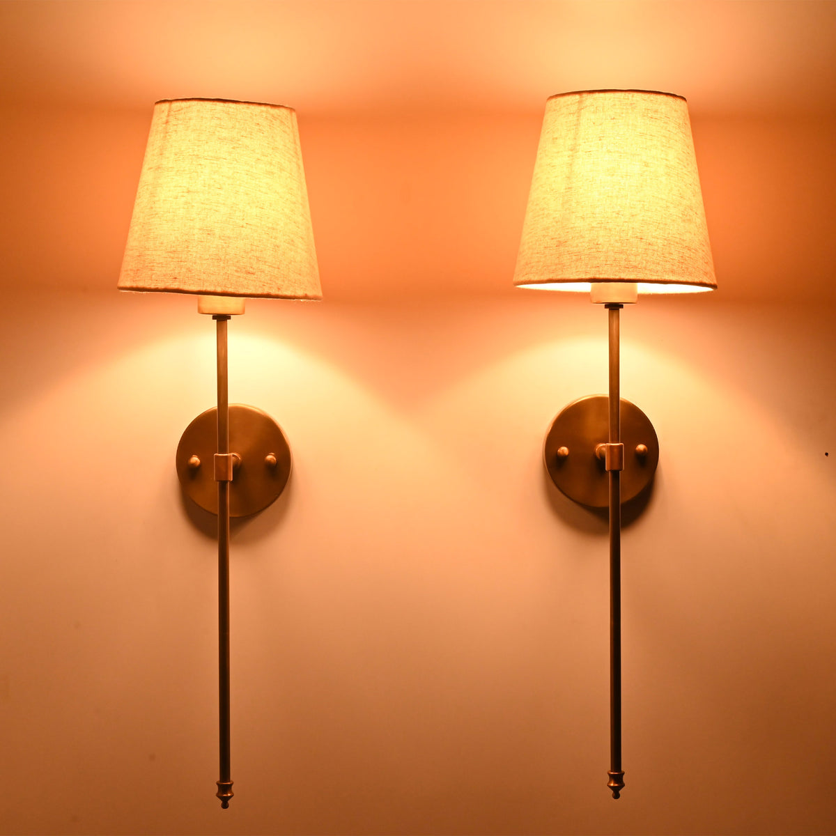 Milan Shade Rod Wall Sconce pair glowing warmly with soft fabric shades and elegant vertical rod design.