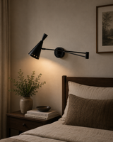 Milan black adjustable swing arm wall sconce installed beside a bed with warm reading light – Model 32806