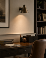 Milan tapered cone wall sconce installed above a modern home office desk, providing warm focused lighting in a contemporary Scandinavian-inspired workspace.