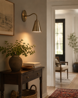 Milan tapered brass cone wall sconce providing warm lighting in an elegant hallway interior – Model 32748