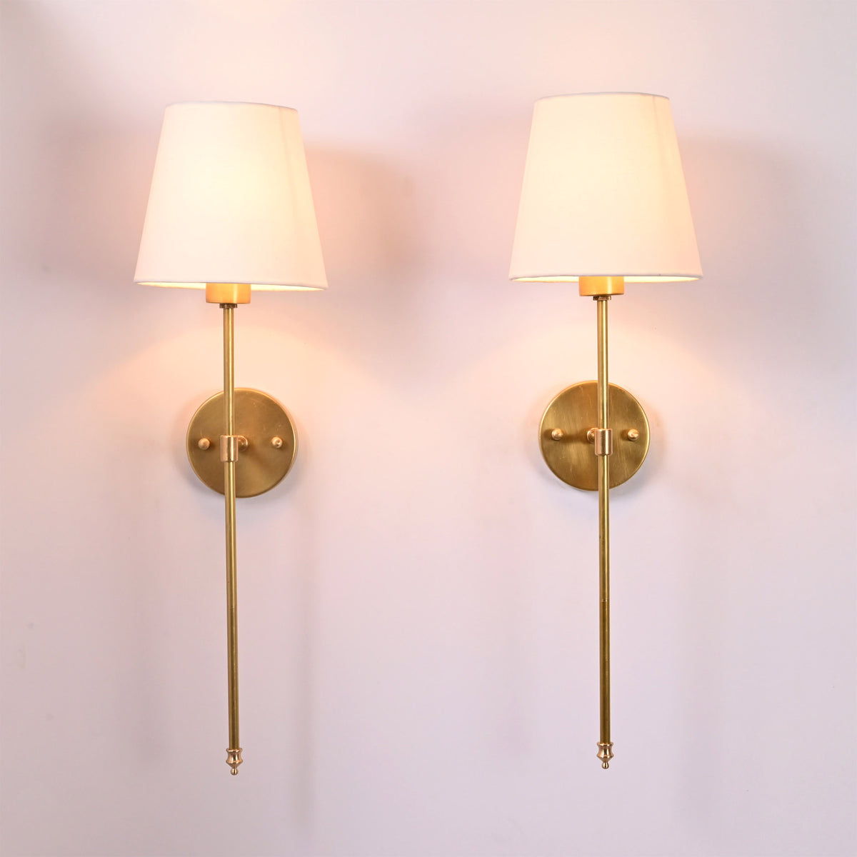 Pair of Milan white shade rod wall sconces with slim vertical frames and warm ambient glow.