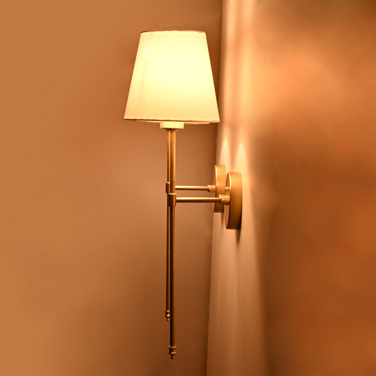 Side angle of Milan white shade wall sconce showing warm light effect and wall projection.