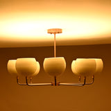 Stylish ceiling chandelier with six frosted glass globes and a warm ambient glow, ideal for contemporary dining rooms or living spaces.