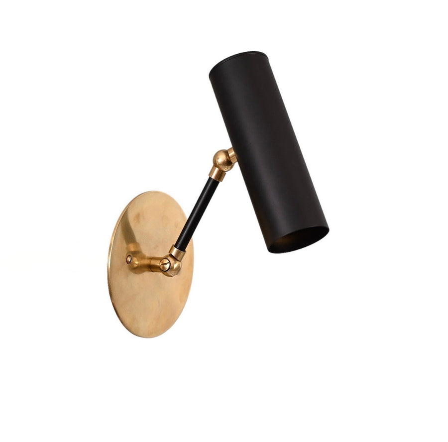 Angled view of adjustable brass wall spotlight with black cylindrical shade and round brass backplate