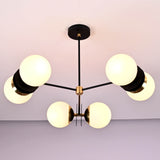 Elegant chandelier with 6 opal glass globes, matte black rods, and polished brass accents, installed on a ceiling for modern interiors.