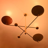 Brass chandelier with colorful shades casting soft golden glow, elegant modern design for ambient interior lighting.