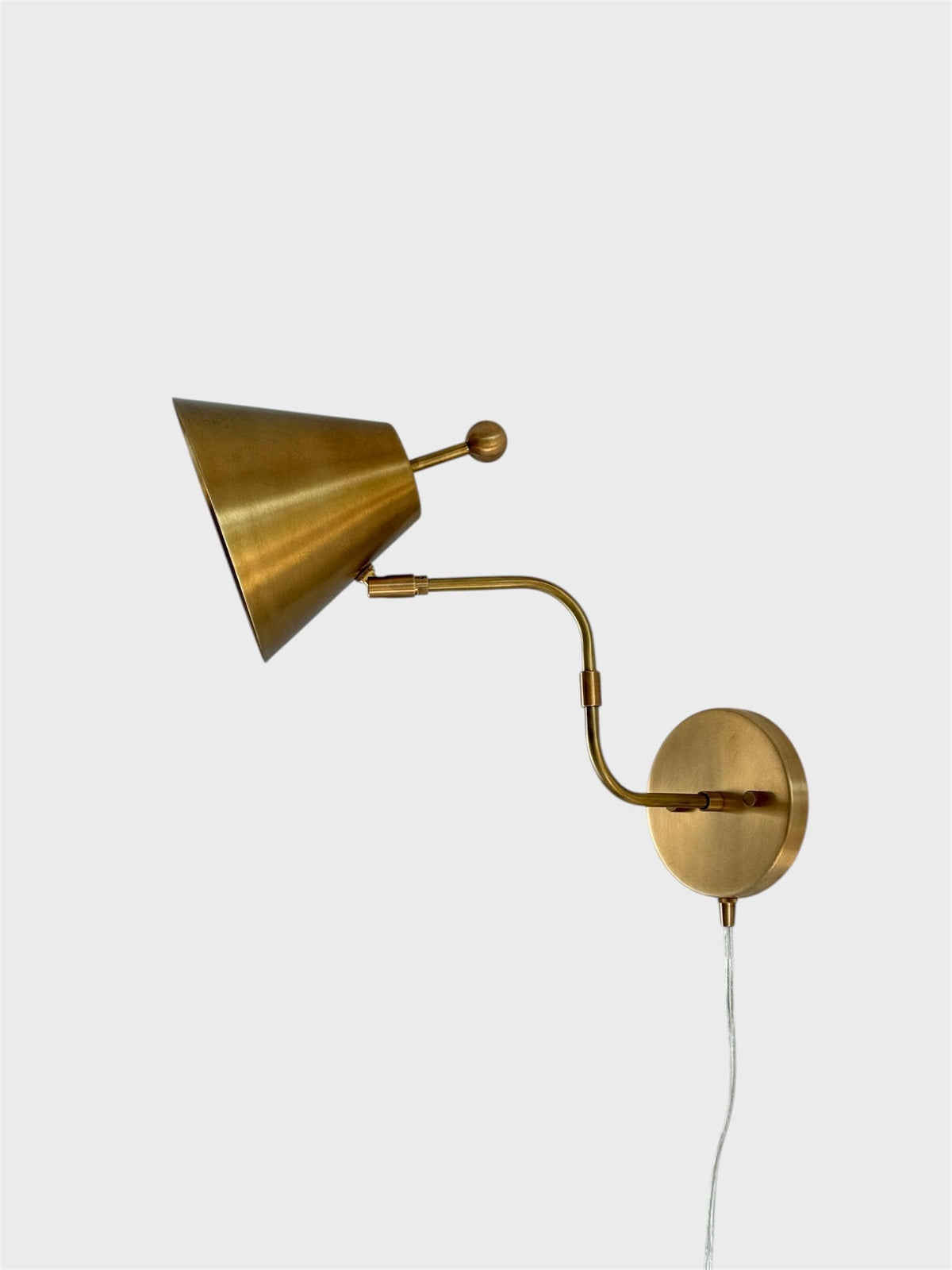Minimal Brass Cone Wall Lamp With Curved Arm And Round Backplate, Plug-In Wall Sconce, Side Profile On White Background