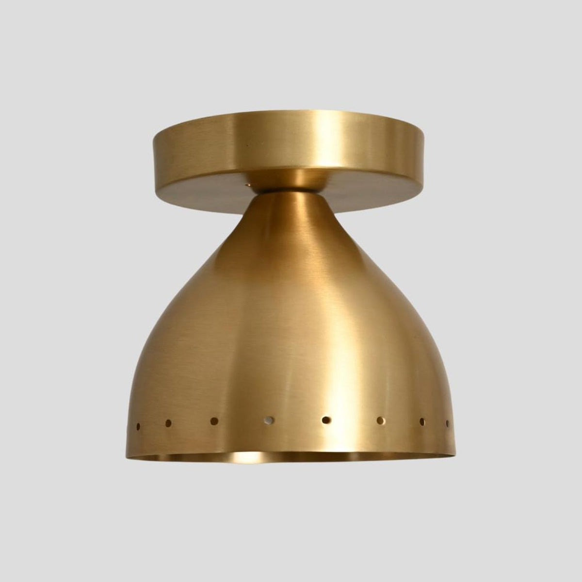 Compact brass flush mount ceiling lamp with brushed satin finish and circular perforations for decorative lighting effects.