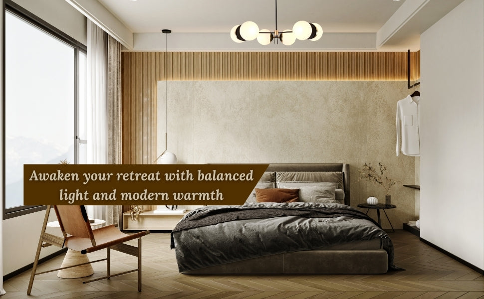 Elegant 6-globe chandelier with brass and black finish illuminating a modern bedroom with cozy tones, wood panel wall, and large windows.