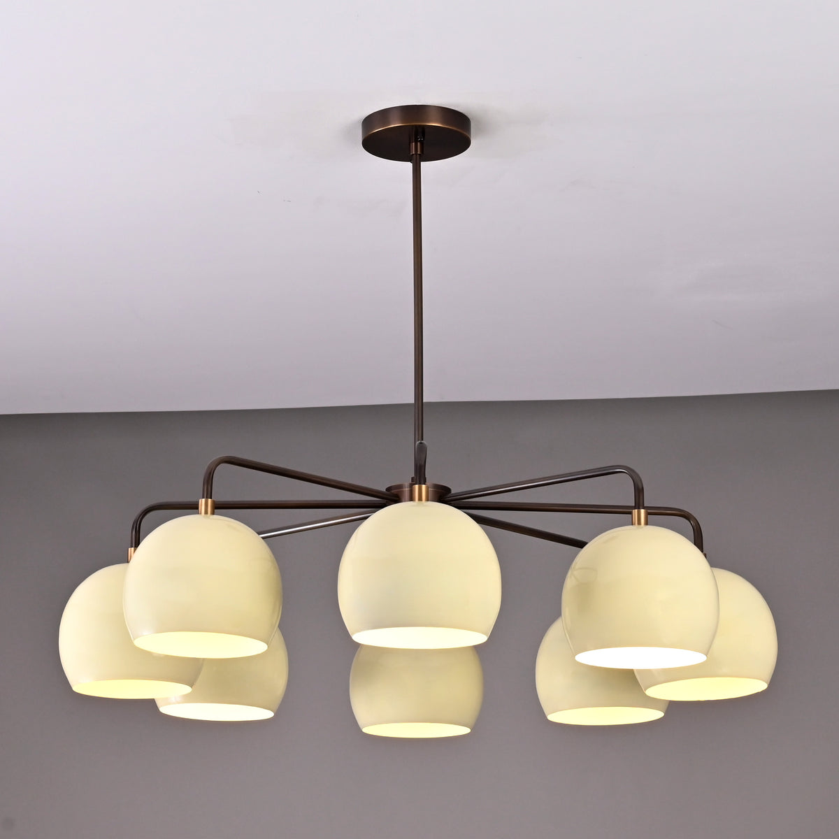 Stylish ceiling chandelier with eight frosted glass globes and a dark metal frame, ideal for contemporary dining or living spaces.