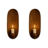 Pair of Monroe modern candle wall sconces with elongated oval backplates and candle-style holders in an antique brass finish.