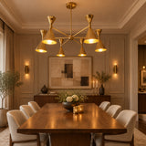 Montpellier 6 light polished brass chandelier featuring illuminated tapered cone shades, sculptural radial arms and warm golden lighting.