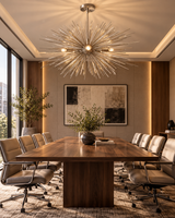 Naples sculptural starburst chandelier hanging above a large walnut conference table in an elegant executive boardroom featuring leather office chairs, modern artwork, and warm architectural lighting.