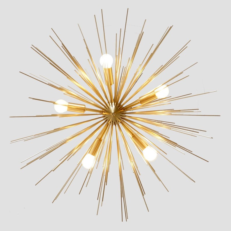 Bottom view of the Naples 5-light sculptural chandelier highlighting five illuminated bulbs surrounded by numerous slender gold-tone rods radiating from a central spherical hub.