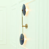 Side profile of Nashville modern wall sconce highlighting curved navy blue metal shades, slender brass framework, and wall-mounted construction.