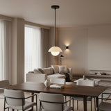 Naxos 1 light dome globe pendant shown from the front with a cream dome shade, glowing globe, and black suspension rod.