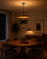 Noir Tiered Disc Chandelier installed above a round dining table in a warm modern interior.