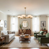 Full view of Orion 6 light chandelier featuring opal glass disc shades and sculptural brass frame.