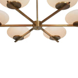 Angled close-up of Orion chandelier showing opal glass shades, brass fittings and sculptural arm design.