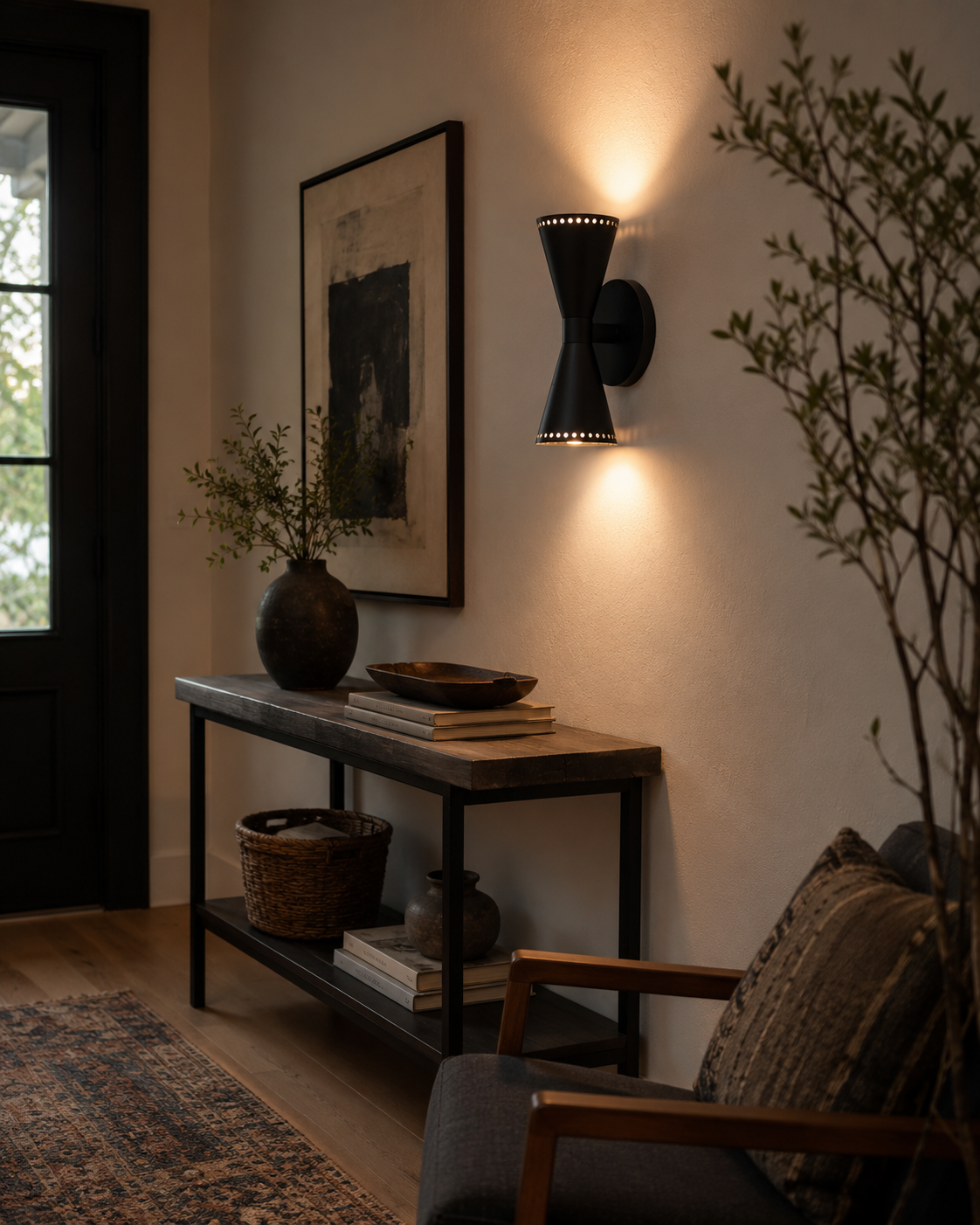 Orion Perforated Double Cone Wall Sconce installed in a modern hallway, casting warm up and down lighting that enhances the contemporary interior décor.