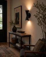 Orion Perforated Double Cone Wall Sconce installed in a modern hallway, casting warm up and down lighting that enhances the contemporary interior décor.