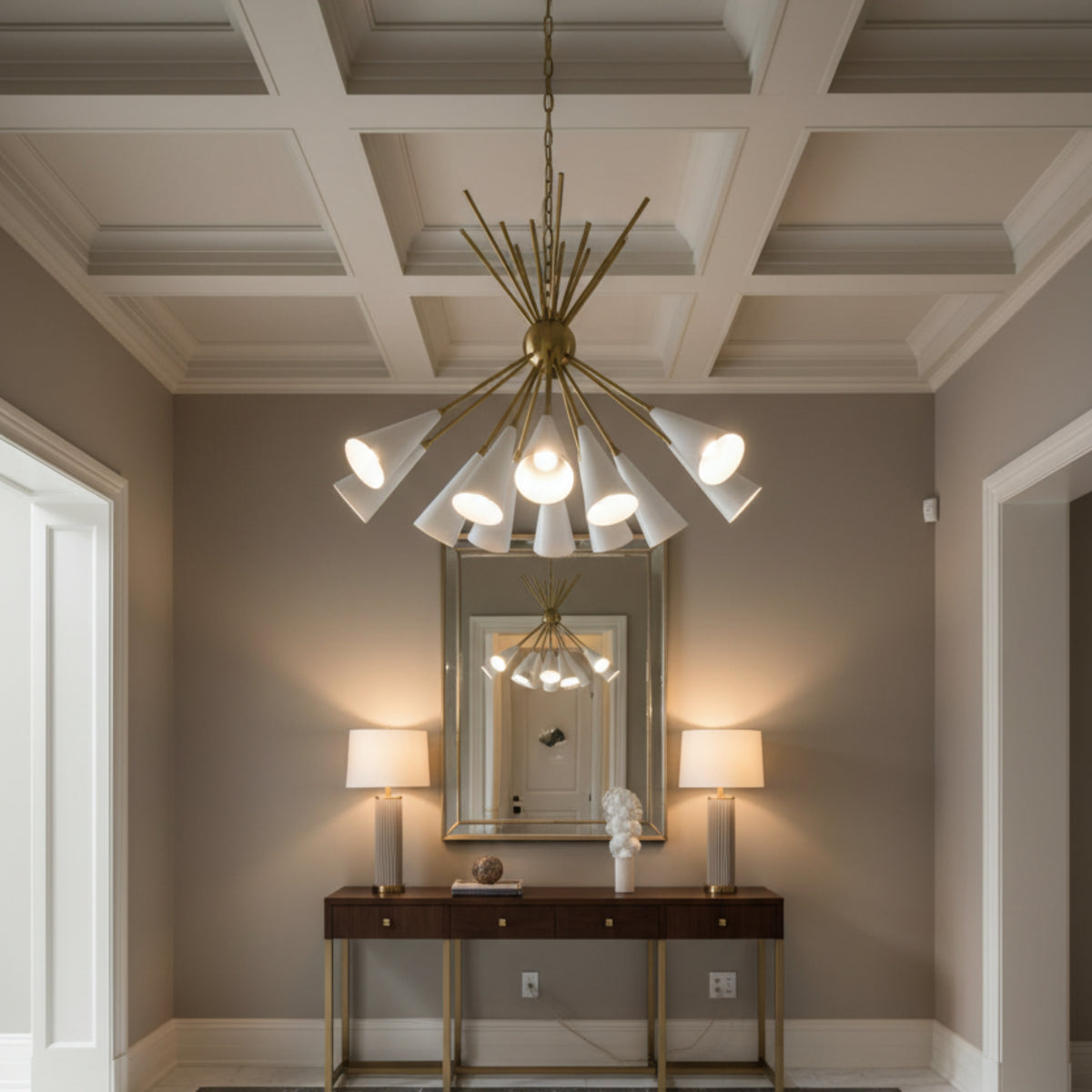 Orion 10 light chandelier with white tapered cone shades, brass arms and sculptural starburst design on a white background.