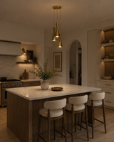 Orion 3 light brass hourglass pendant chandelier installed above a modern kitchen island with warm ambient lighting.