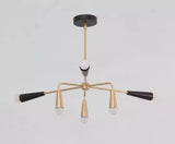 Angled view of the Osaka 6-light black and brass chandelier showcasing its asymmetrical multi-arm arrangement, tapered metal cone holders, curved brass-tone supports, and white globe bulbs.