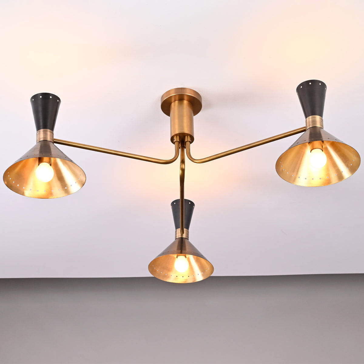 Angled view of Oslo Cone Arm Chandelier highlighting three directional cone shades and perforated shade detailing.