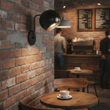 Oslo dome wall sconce in black finish with rounded metal shade, globe bulb and matching wall mount.