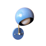 Oslo dome wall sconce with blue rounded metal shade, globe bulb and brass arm, angled front view.